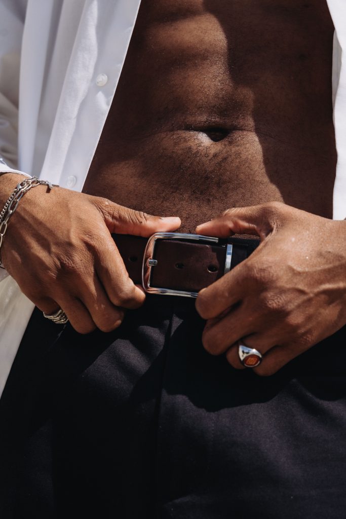 Gentleman fastening a premium leather belt.